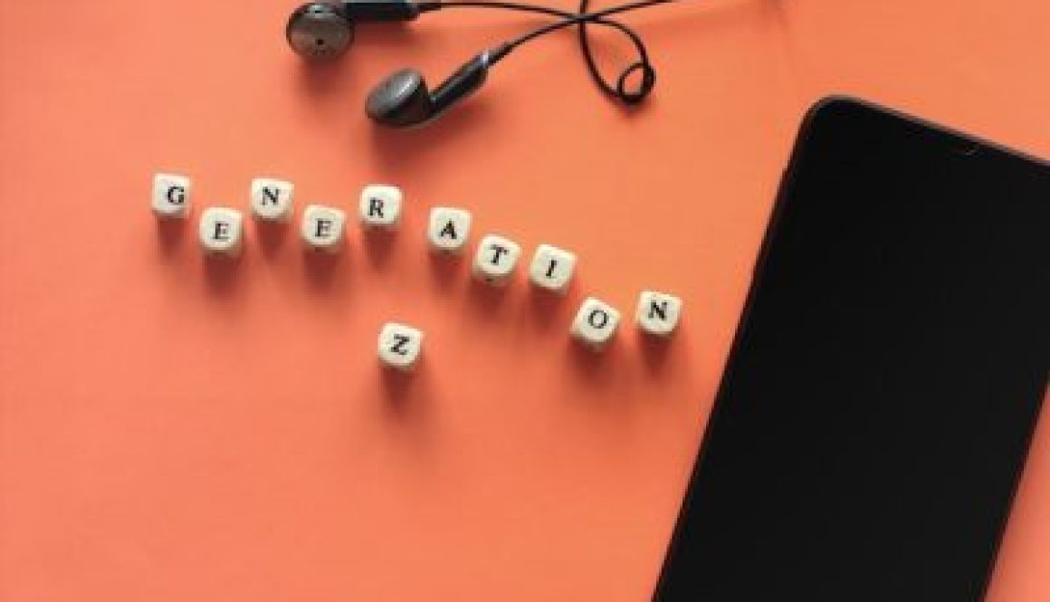 black smartphone and earphones. Dice with letters Generation Z.